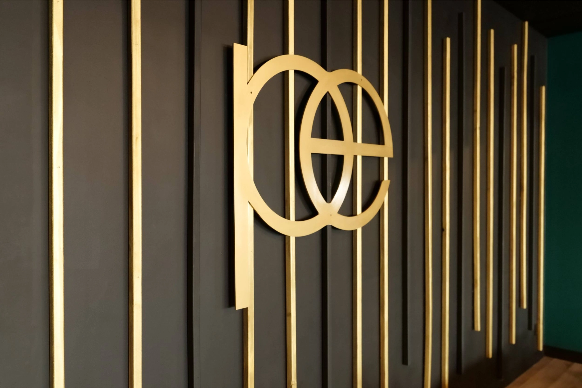 Gold Pilates Evolution monogram on the striped studio wall